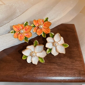 Detail of vintage flower earrings with colorful enamel petals and tiny center pearls