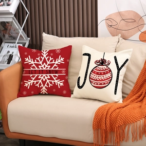 Christmas linen pillowcases with Snow and Joy patterns on a cozy living room sofa