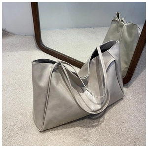 Close-up of beige faux leather tote bag showing smooth texture and large interior space