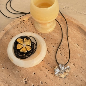 Vintage 18k gold and silver flower pendant necklace on minimalist black leather cord