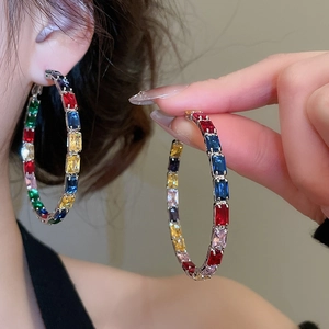 Macro shot of colorful zircon hoop earrings featuring a multi-color gemstone pave setting