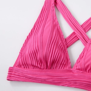 Detailansicht eines pinkfarbenen Bikini-Oberteils mit Textur und Kreuzträgern