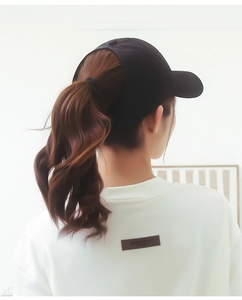 Detailed back view of a black ponytail baseball cap showing the large functional opening cutout