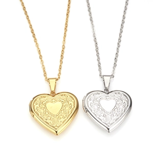 Gold and silver heart locket necklaces with floral engraving on a white background