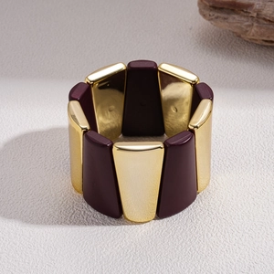 Macro shot of purple acrylic and gold metal trapezoid segments on an elastic bracelet
