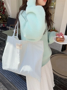 Mint green striped canvas tote bag in a casual lifestyle setting for daily commuting