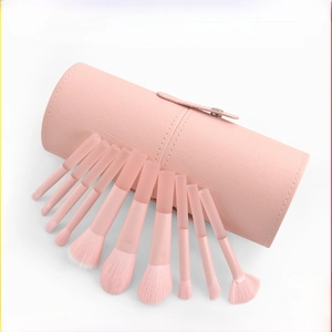 Detail of 10 peach pink makeup brushes with gradient bristles and pink leather travel case