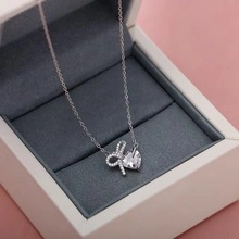 Close-up of S925 silver necklace with bow and heart zircon pendant in a premium gift box