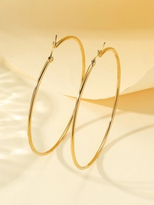 Detailed view of large gold hoop earrings with polished finish and latch back closure