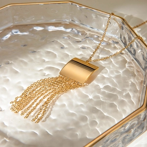 Macro view of gold geometric square pendant with elegant long chain fringe tassels