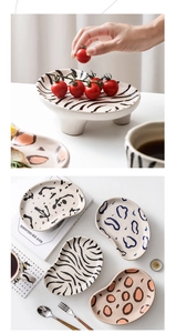 Detail of irregular ceramic plate with hand-painted zebra and leopard patterns