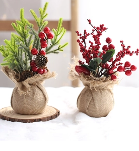 Detailed view of mini Christmas trees with pine needles, berries and burlap wrapped bases