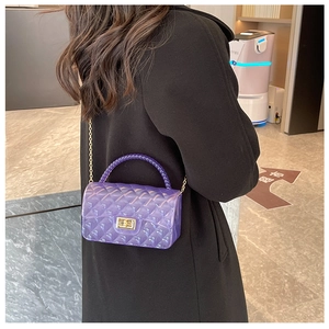 Detail of purple transparent jelly bag with quilted pattern, gold chain and woven handle