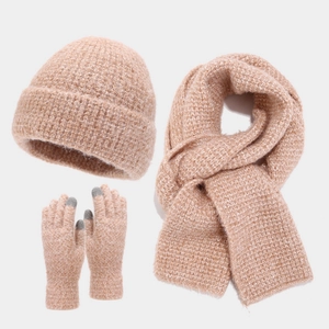Detail of chunky knit winter set featuring thick scarf, beanie, and touchscreen gloves