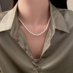 Vue détaillée d'un collier de perles blanches de style vintage français sur un mannequin
