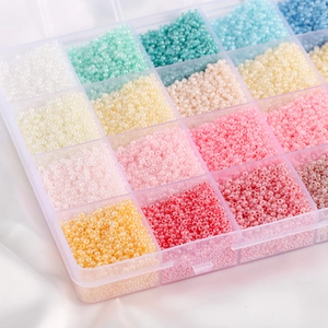 Detailed macro view of multi-color glass seed beads set in a clear plastic storage organizer