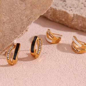 Detailed macro shot of U-shaped gold plated earrings with enamel inlay and micro zircon