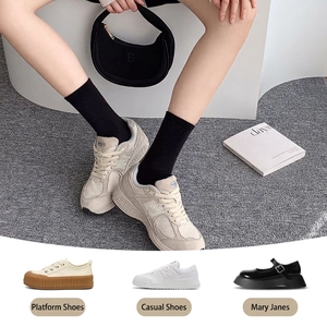 Classic black cotton crew socks for women styled with casual sneakers on a soft carpet