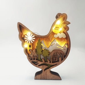 Detailed laser-cut wooden hen ornament with warm LED lighting and layered farm scene
