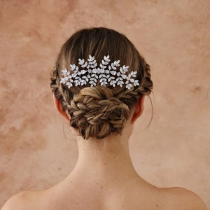 Dettaglio del pettine da sposa in argento con foglie di zircone su uno chignon elegante