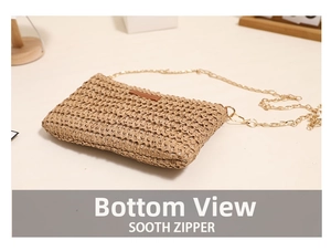 Detail view of woven straw beach bag showing bottom structure and golden chain strap