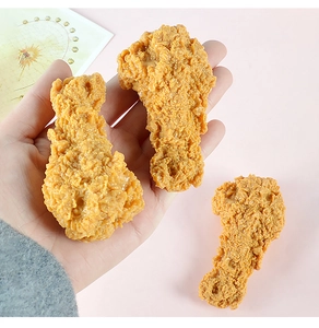Dettaglio di modelli di cosce di pollo fritto in PVC con texture dorate realistiche