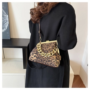 Close-up of leopard print shell bag with chunky gold chain and vintage metal clasp