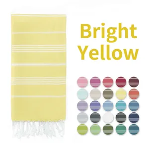 Detail view of bright yellow striped Turkish towel with white fringe and color palette