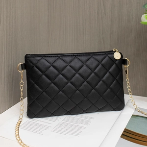 Sac bandoulière noir matelassé classique avec chaîne dorée sur fond texturé