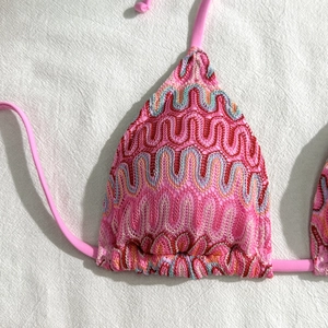 Détail de la broderie à vagues colorées sur le haut de bikini rose avec liens à nouer