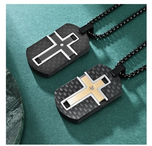 Macro shot of carbon fiber military tags with gold and silver cross pendants on marble