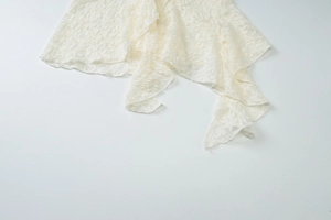 Close-up of white lace fabric detailing with intricate patterns and elegant ruffles