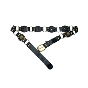 Close-up of vintage brown leather belt with brass hardware rings and decorative rivets