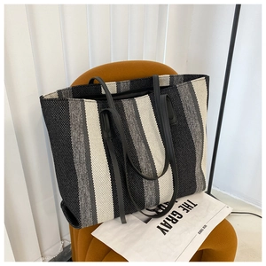 Detailed texture of black and white striped canvas tote bag on an orange chair