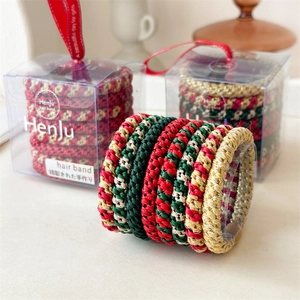 Detail of Christmas elastic hair bands in red and green colors with festive gift box packaging