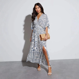 Bohemian floral maxi dress with deep V-neck, bell sleeves and side slit in blue and white