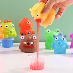 Funny yellow duck squeezing toy spitting red slime into a cup, stress relief toy