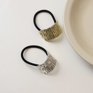 Detail of gold and silver hair ties with irregular textured metallic accents