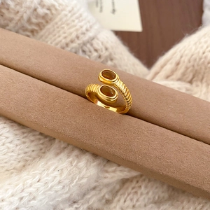 Macro detail of cross open ring with amber oval stones on brown velvet stand