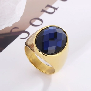 Detail of faceted oval blue crystal on a polished gold-plated stainless steel ring band