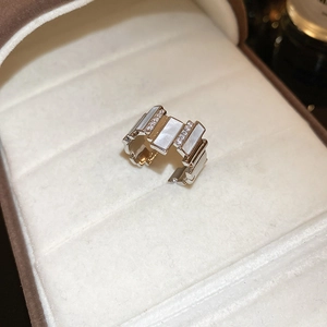 Macro detail of geometric silver and gold ring with mother of pearl and zircon stones