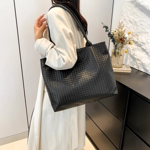Large black woven leather tote bag for women showing spacious casual hobo style