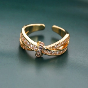 Macro detail of gold-plated crossover open ring with pavé micro-set cubic zirconia