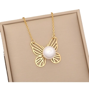 Elegant gold butterfly pendant necklace with white pearl on a jewelry box display
