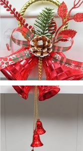 Detail of red Christmas bells with gold ring, plaid ribbon and pine cones decoration