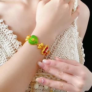 Detail of vintage gold enamel bracelet with green and red hearts and pearl accents