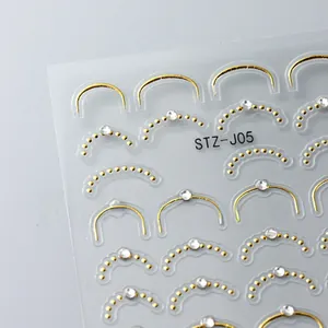 Détail macro de stickers ongles 5D avec lignes dorées métalliques et strass blancs brillants