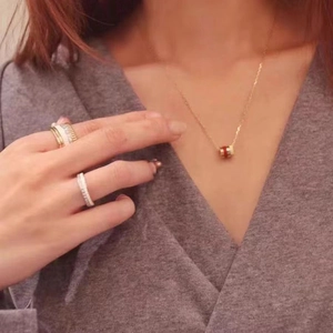 Classic 18K rose gold couple ring and cylinder pendant necklace set on female model