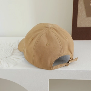Detail view of khaki cotton baseball cap showing adjustable metal buckle and fabric texture