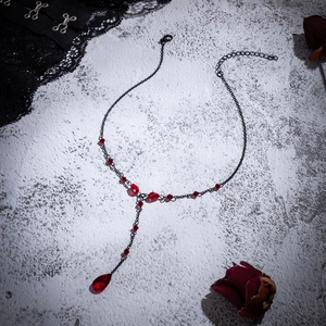 Close-up of Gothic choker with blood-red crystal tassels and black metal chain detail